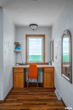 a room with lounge chair windows and wooden floor
