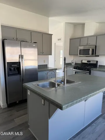 a kitchen with stainless steel appliances granite countertop a sink a stove and a refrigerator