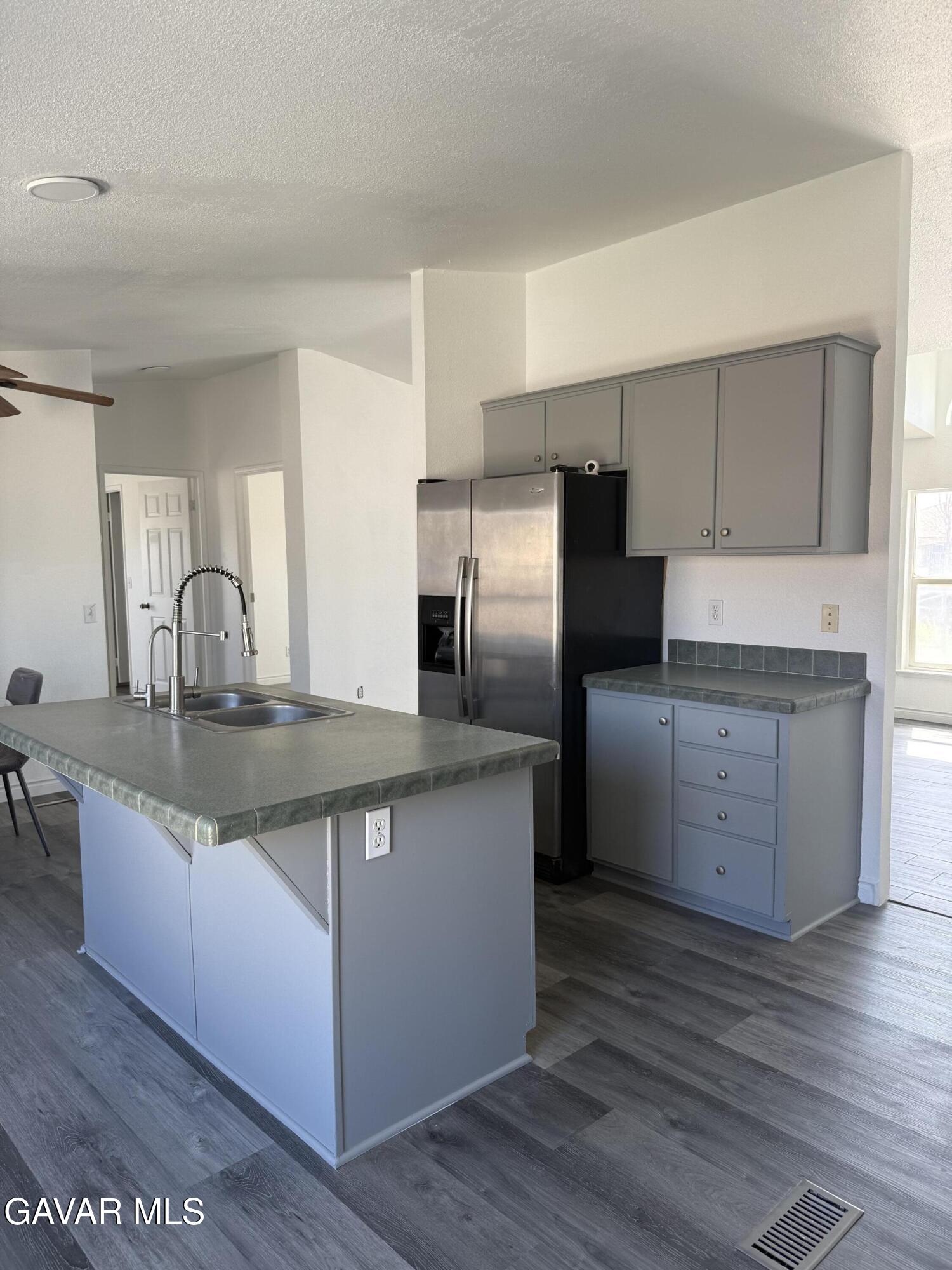 1365 Richfield Avenue Rosamond, CA 93560 - Photo 6 of 17 a kitchen with stainless steel appliances granite countertop a sink stove and refrigerator