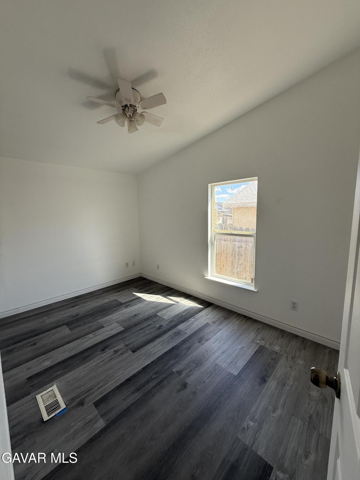 1365 Richfield Avenue Rosamond, CA 93560 - Photo 8 of 17 an empty room with wooden floor cabinet and windows