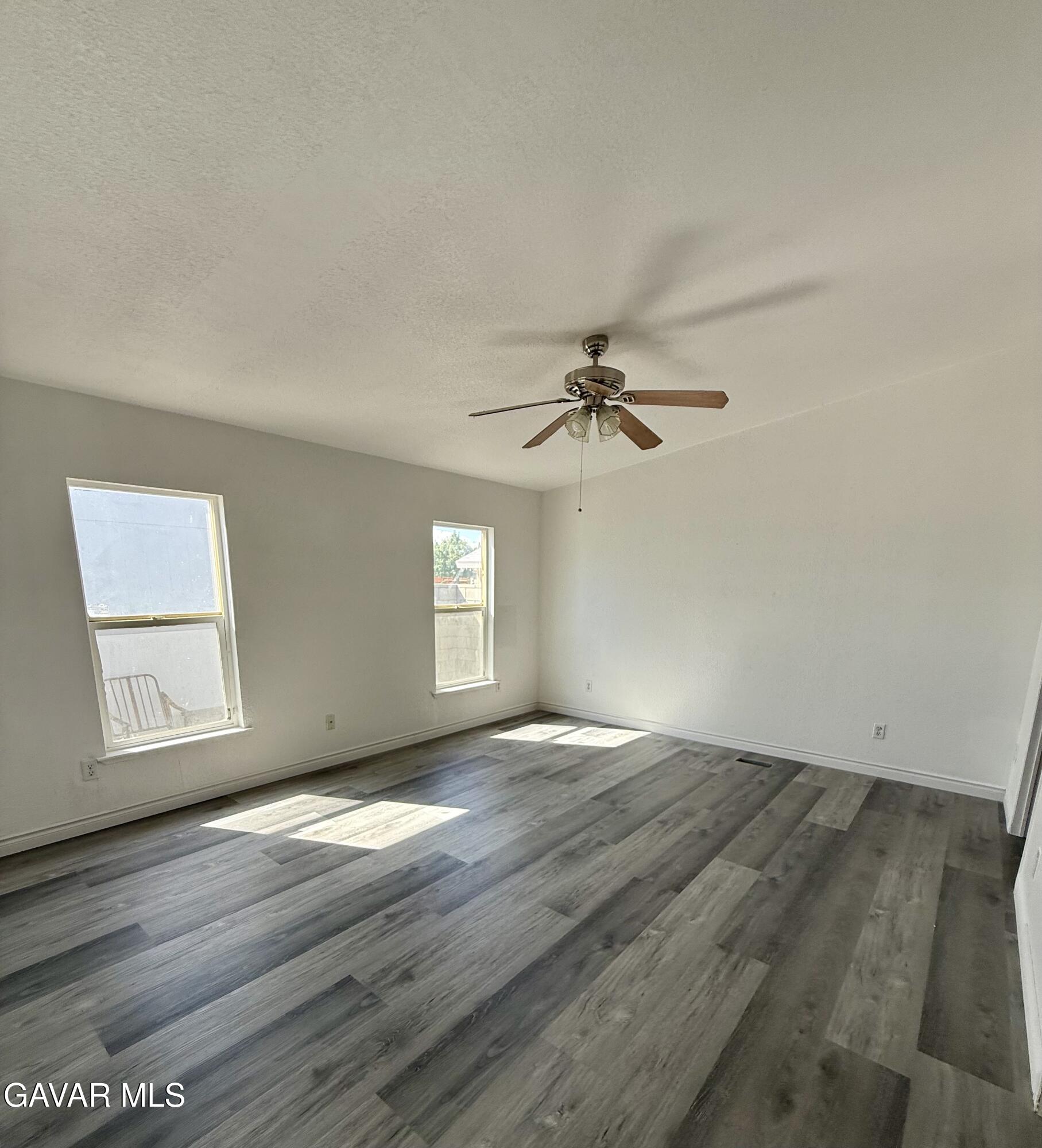 1365 Richfield Avenue Rosamond, CA 93560 - Photo 9 of 17 a view of empty room with wooden floor and fan