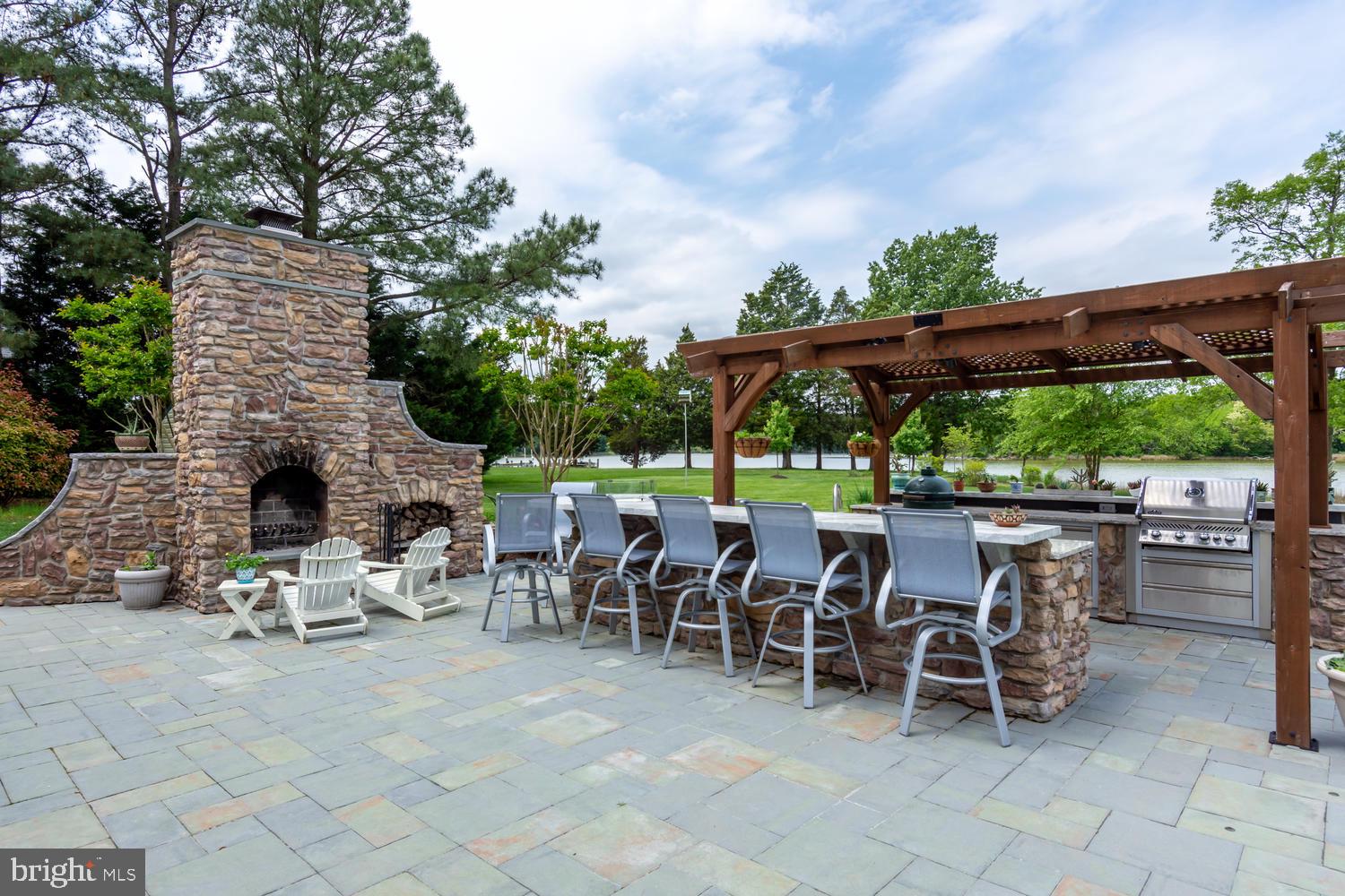 25474 Chance Farm Road St. Michaels, MD 21663 - Photo 6 of 52 Outdoor kitchen with dining bar and fireplace