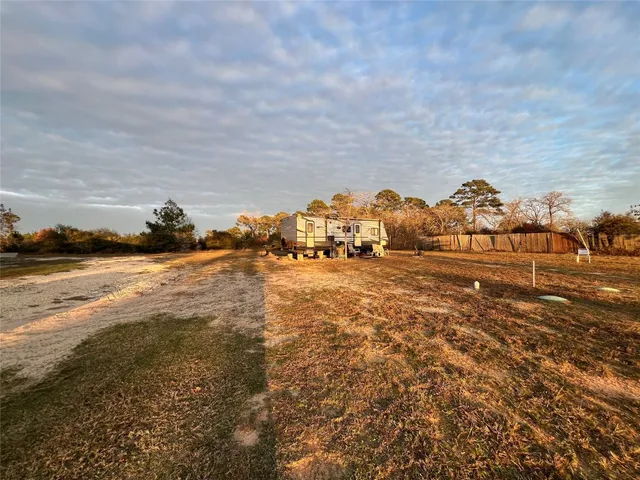 a view of a yard with wooden fence