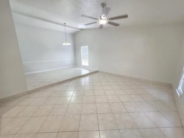 an empty room with a ceiling fan and a shower