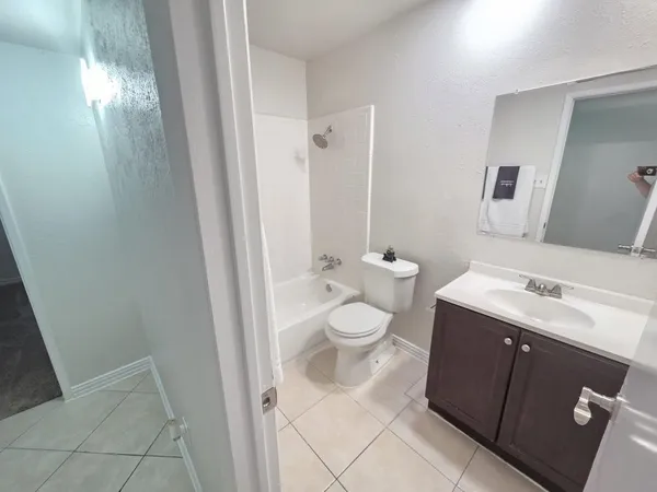 a bathroom with a toilet a sink a mirror and vanity