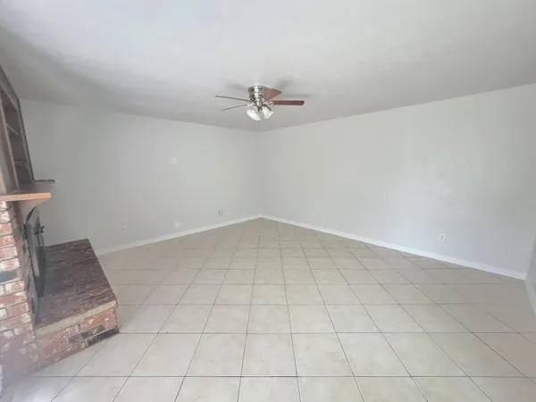 an empty room with a ceiling fan and a rug