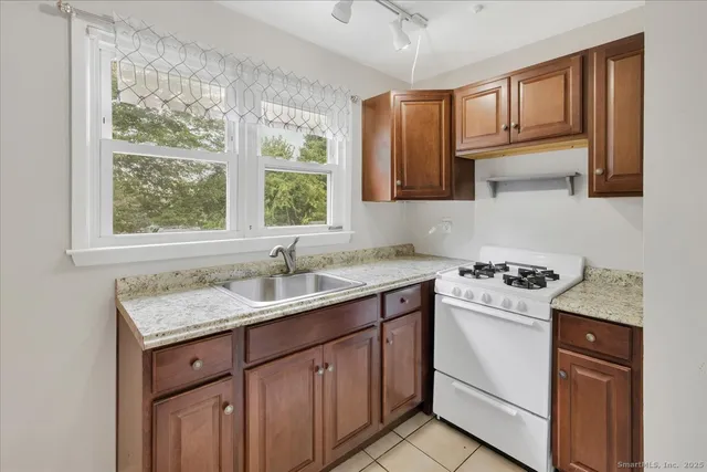a kitchen with a sink stove top oven and cabinets