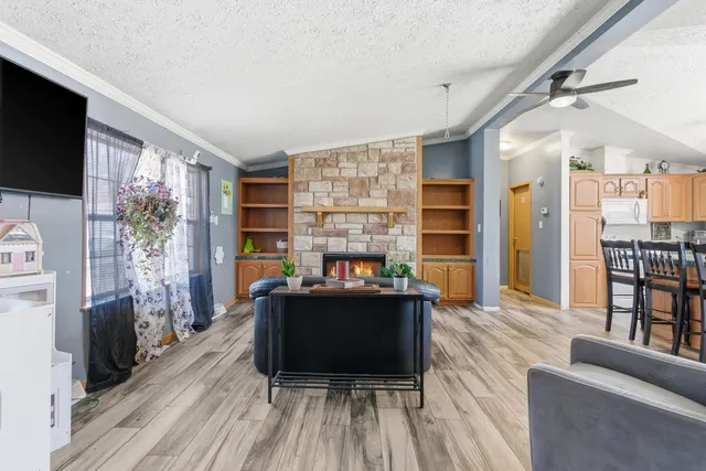 a living room with furniture a flat screen tv and a floor to ceiling window