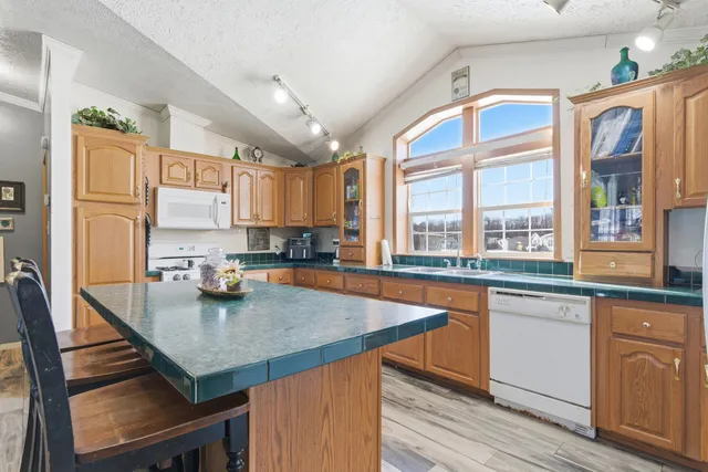 a kitchen with stainless steel appliances granite countertop a sink a stove and cabinets