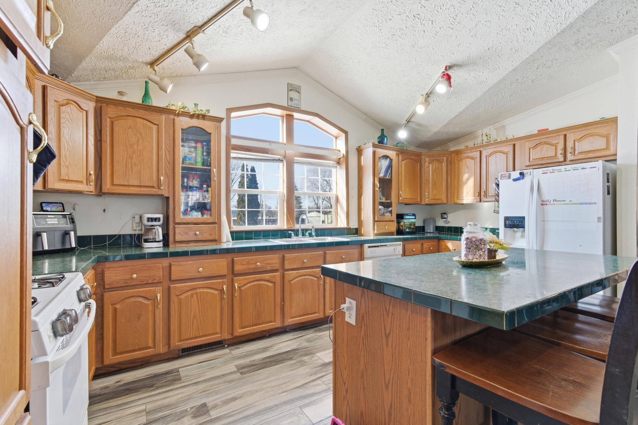 4827 East 994 North Demotte, IN 46310 - Photo 9 of 25 a kitchen with stainless steel appliances granite countertop a stove a sink dishwasher and a refrigerator with wooden cabinets