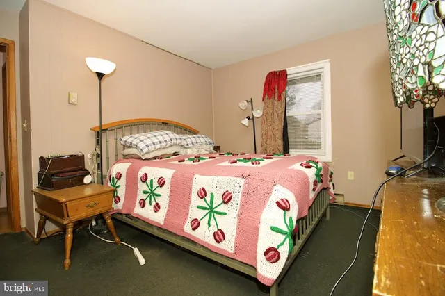 a bedroom with a bed table and a chair