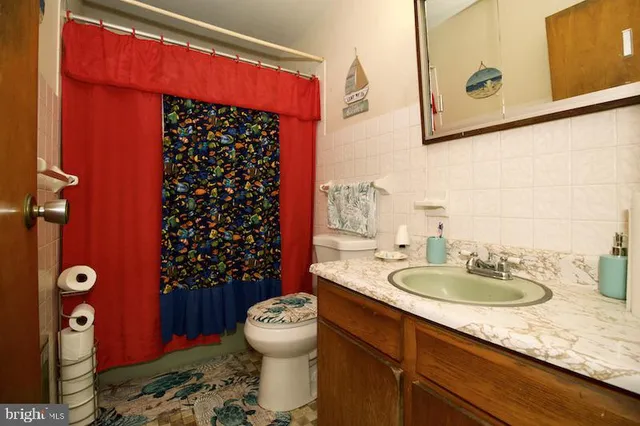 a bathroom with a sink a toilet and shower curtain