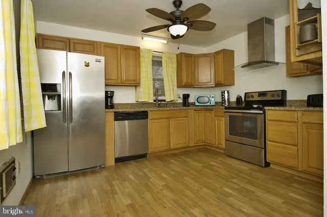 a kitchen with stainless steel appliances granite countertop a sink a stove a refrigerator cabinets and a dining table