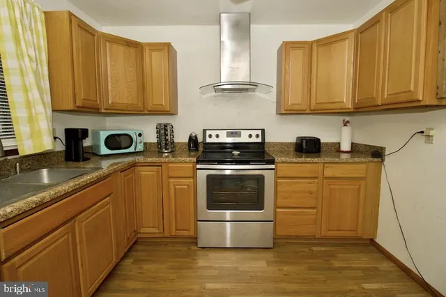 a kitchen with stainless steel appliances granite countertop a stove a sink and a refrigerator