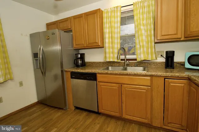 a kitchen with stainless steel appliances granite countertop a refrigerator sink and cabinets
