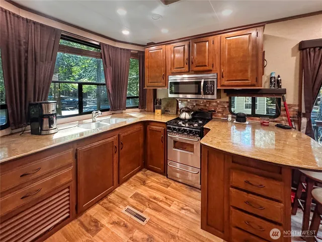 a kitchen with stainless steel appliances granite countertop a refrigerator and a sink