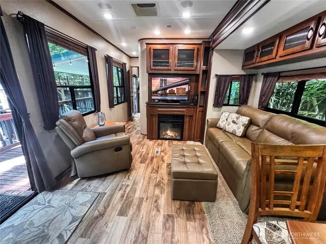 a living room with furniture a fireplace and a floor to ceiling window