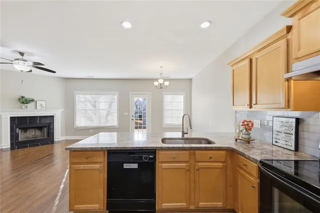a kitchen with stainless steel appliances granite countertop a sink stove and cabinets