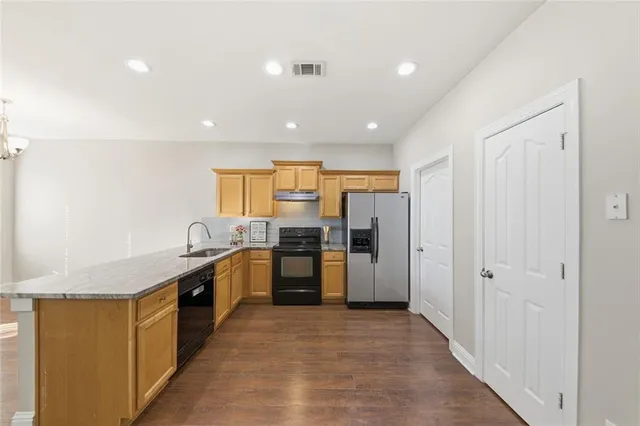 a kitchen with stainless steel appliances granite countertop a refrigerator and a sink