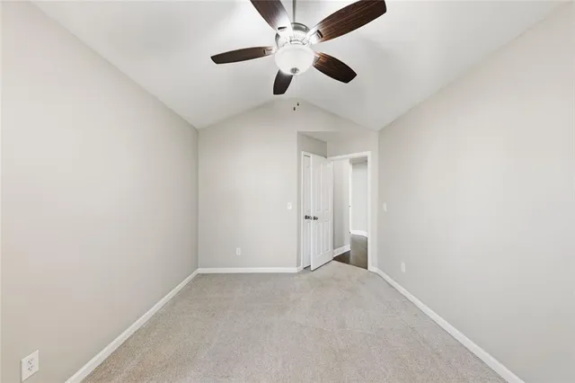 an empty room with a ceiling fan and a window