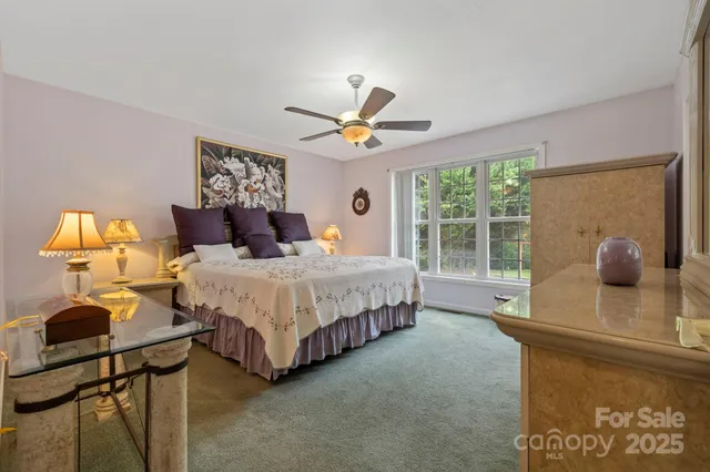 a bedroom with a bed and a large window with mirror