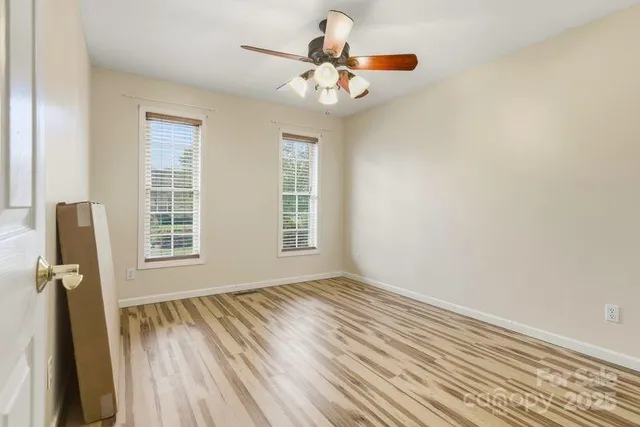 an empty room with windows and cabinet