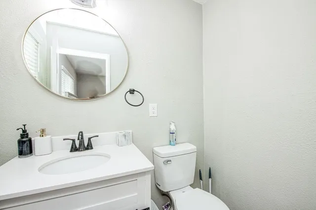 a bathroom with a sink mirror and toilet