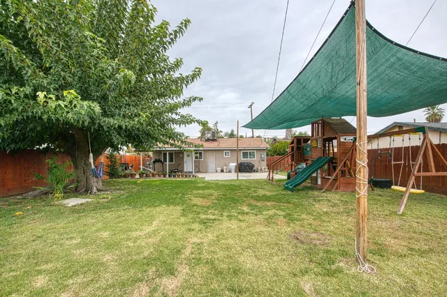 a view of a house with a yard and sitting area