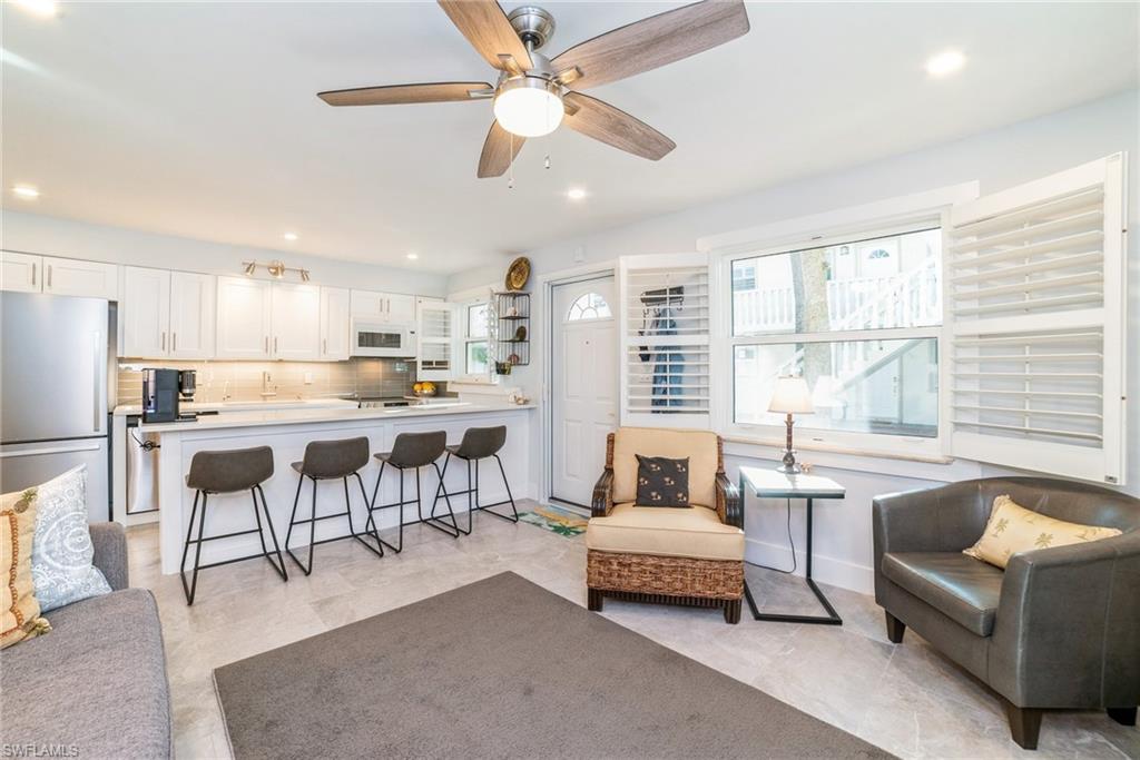 980 7th Avenue South, Unit 101 Naples, FL 34102 - Photo 8 of 32 a living room with furniture and a large window with kitchen view