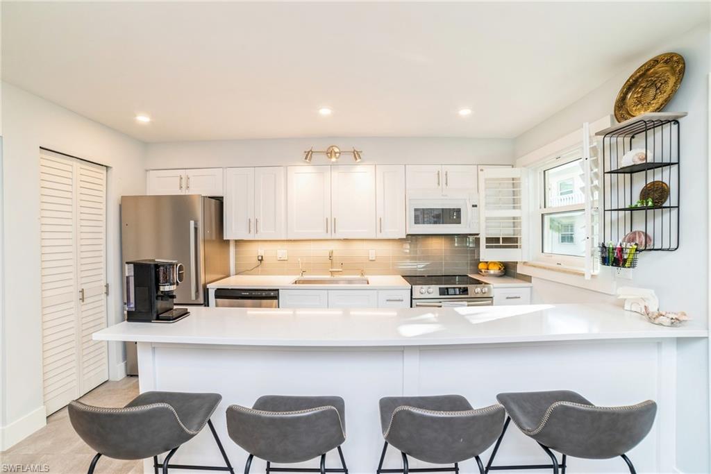 980 7th Avenue South, Unit 101 Naples, FL 34102 - Photo 9 of 32 a kitchen with a sink cabinets and window