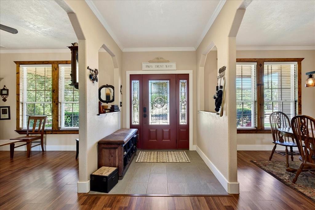 11591 Farm To Market 59 Athens, TX 75751 - Photo 5 of 40 Entryway featuring a decorative transom, leaded glass sidelights, and a rich red front door. Flex space/Office is on the right and dining area is on the left.