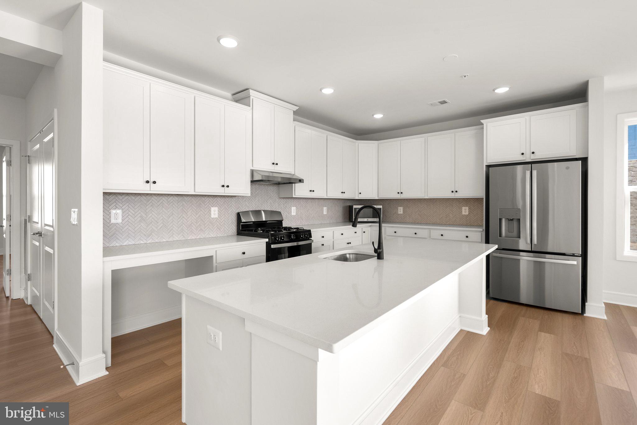 a kitchen with a refrigerator a white cabinets and white stainless steel appliances