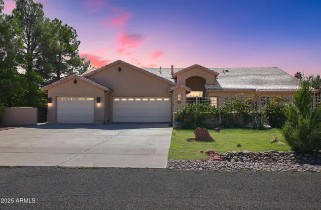 a front view of a house with a yard and a garage