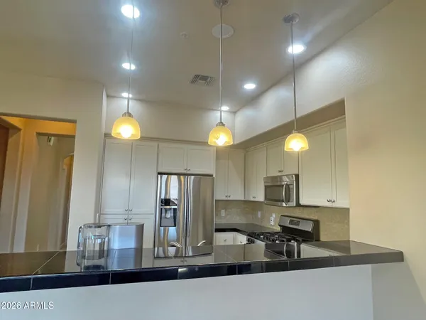 a kitchen with kitchen island granite countertop a sink and refrigerator