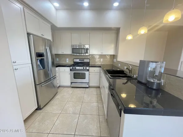 a kitchen with a sink appliances and cabinets