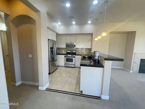 a kitchen with stainless steel appliances kitchen island granite countertop a refrigerator and a stove top oven