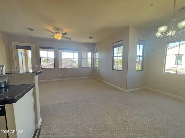 an empty room with a kitchen and windows