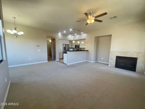 a view of a livingroom with a ceiling fan a kitchen space and a ceiling fan