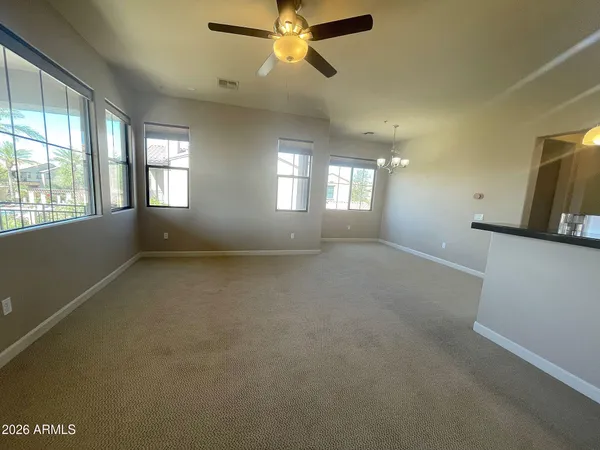 en empty room with windows and ceiling fan
