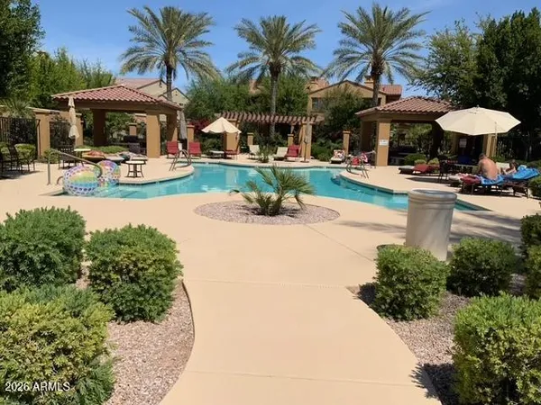 a view of a table and chairs under an umbrella with palm trees