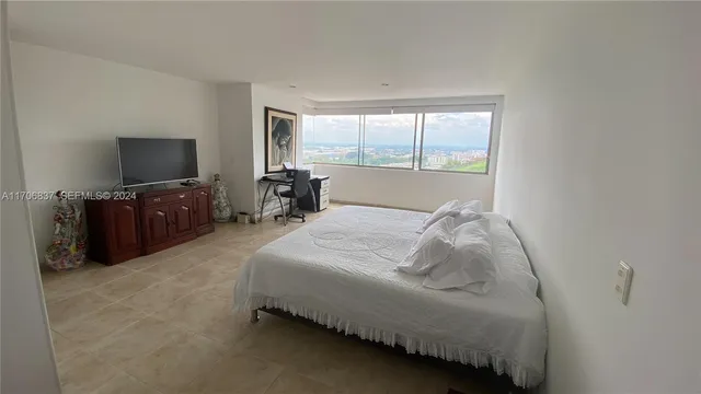 a bed sitting in a bedroom next to a window with tv