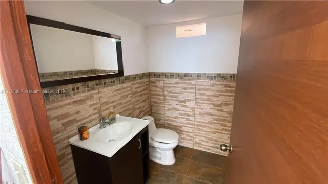 a bathroom with a toilet sink and mirror