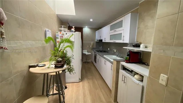 a kitchen that has a sink cabinets and wooden floor