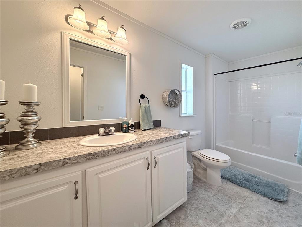 101 St Johns Way West Apollo Beach, FL 33572 - Photo 11 of 24 a bathroom with a granite countertop sink toilet a mirror and shower