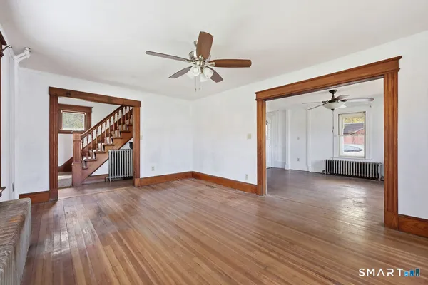 an empty room with windows and ceiling fan