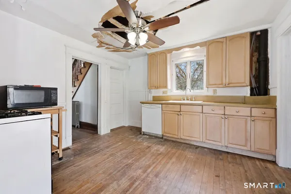 a view of kitchen with granite countertop a sink and a stove top oven