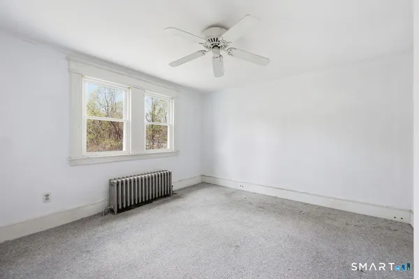 an empty room with a window and a ceiling fan