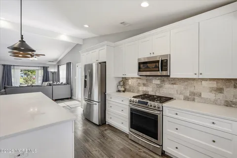 a kitchen with granite countertop a refrigerator stove and microwave