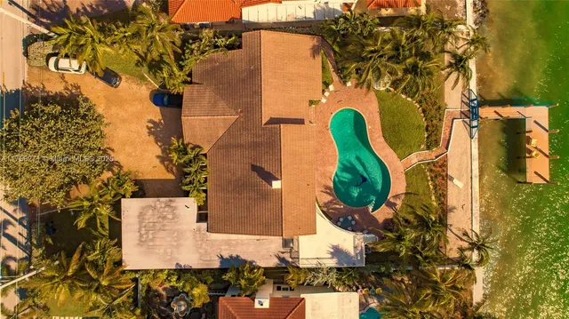 an aerial view of a house with a yard and large trees