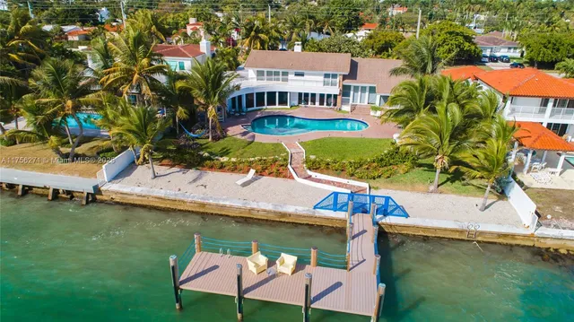 an aerial view of a house with swimming pool outdoor seating